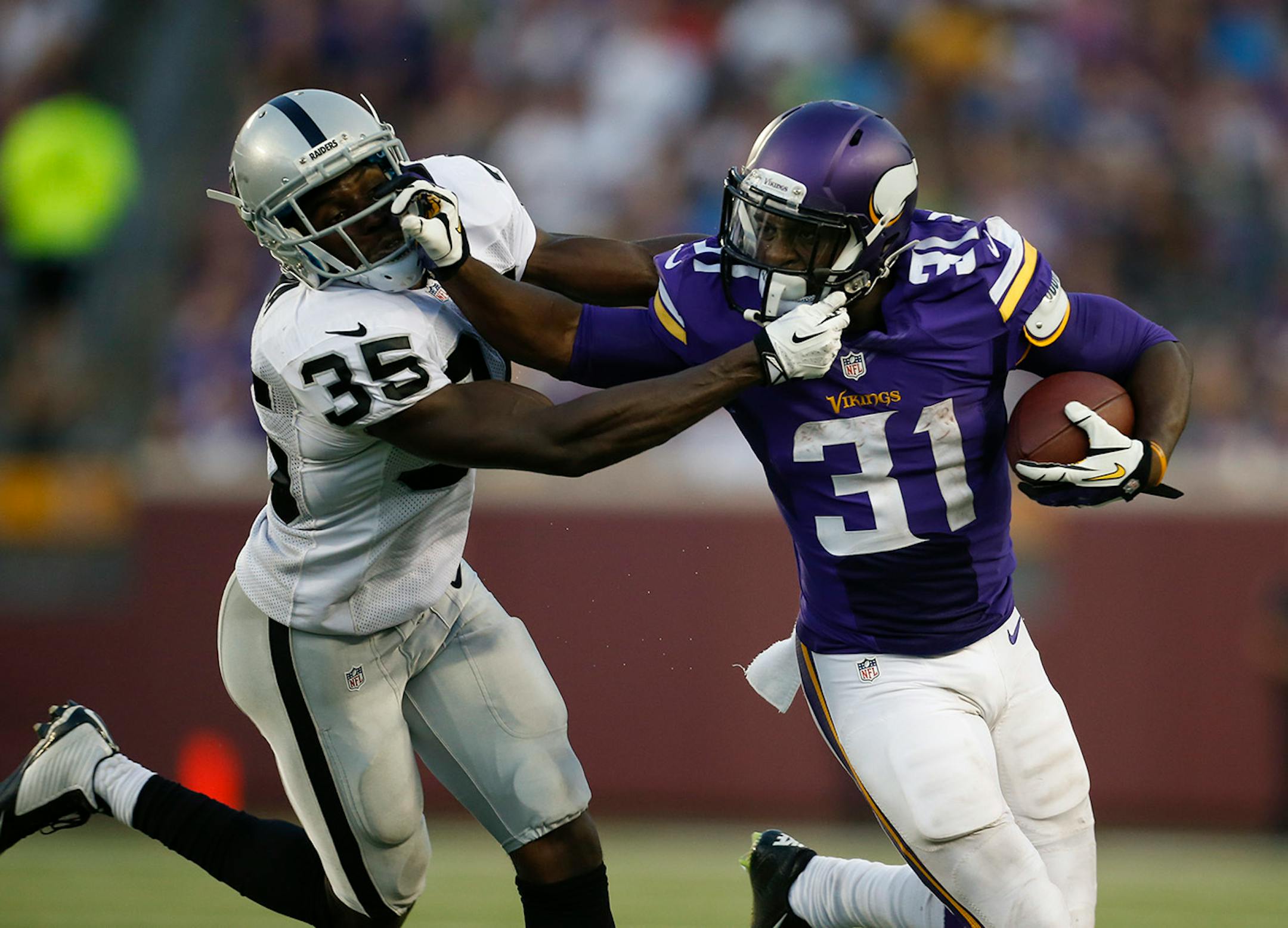 Minnesota Vikings running back Jerick McKinnon (31) stiff armed Oakland Raiders defensive back Chimdi Chekwa (35) as he made a two yard gain in the second quarter Thursday evening.