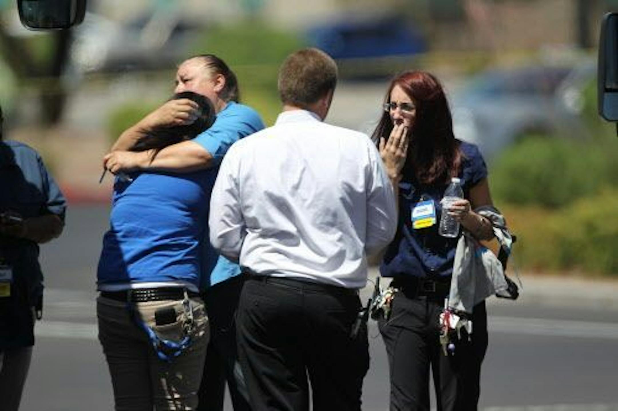 Wal-Mart employees hug outside a store after a shooting at the store and a nearby CiCi's Pizza in Las Vegas, Sunday, June 8, 2014.