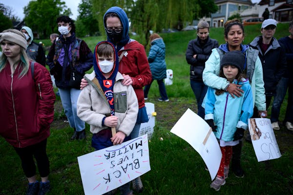 Community members bowed their heads during a vigil at the Say Their Names Cemetery on the second anniversary of George Floyd’s murder last May in Mi