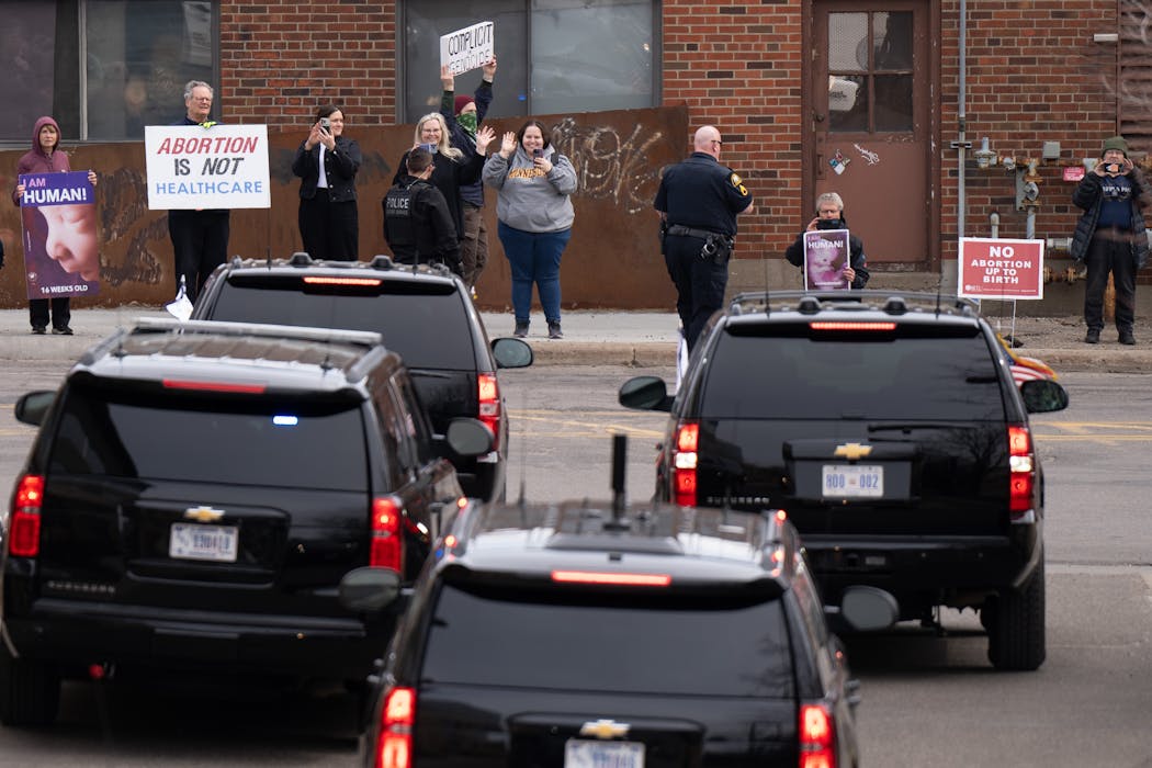 A small group of protesters gathers Thursday across the street from the Planned Parenthood clinic in St. Paul as Vice President Kamala Harris’ motorcade drives away.
