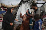 Displaced Palestinians inspect their tents destroyed by Israel's bombardment, adjunct to an UNRWA facility west of Rafah city, Gaza Strip, Tuesday, Ma