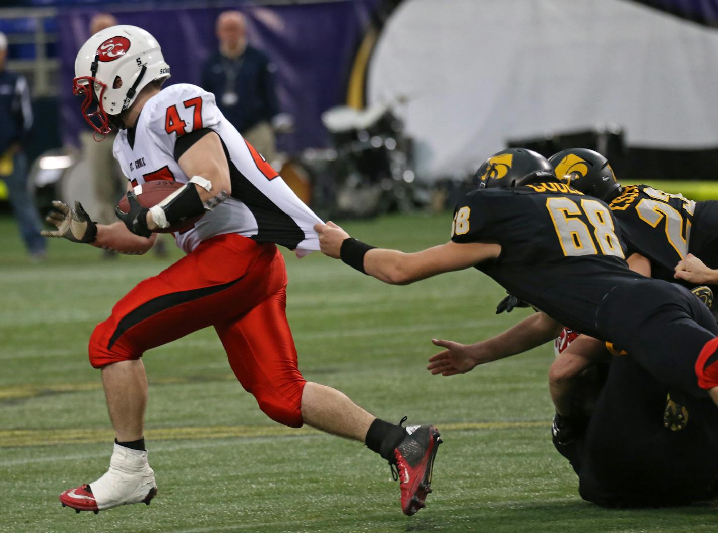 Minnesota State High School League Prep Bowl Championship Games, Metrodome, 11/30/13. St. Croix Lutheran vs. New London-Spicer, Class 3A Championship. (left to right) St. Croix Lutheran's Trever Koester ran for a touchdown in the first play of the game as New London-Spicer's Luke Gould tried to pull him down.] Bruce Bisping/Star Tribune bbisping@startribune.com Trever Koester, Luke Gould/roster.