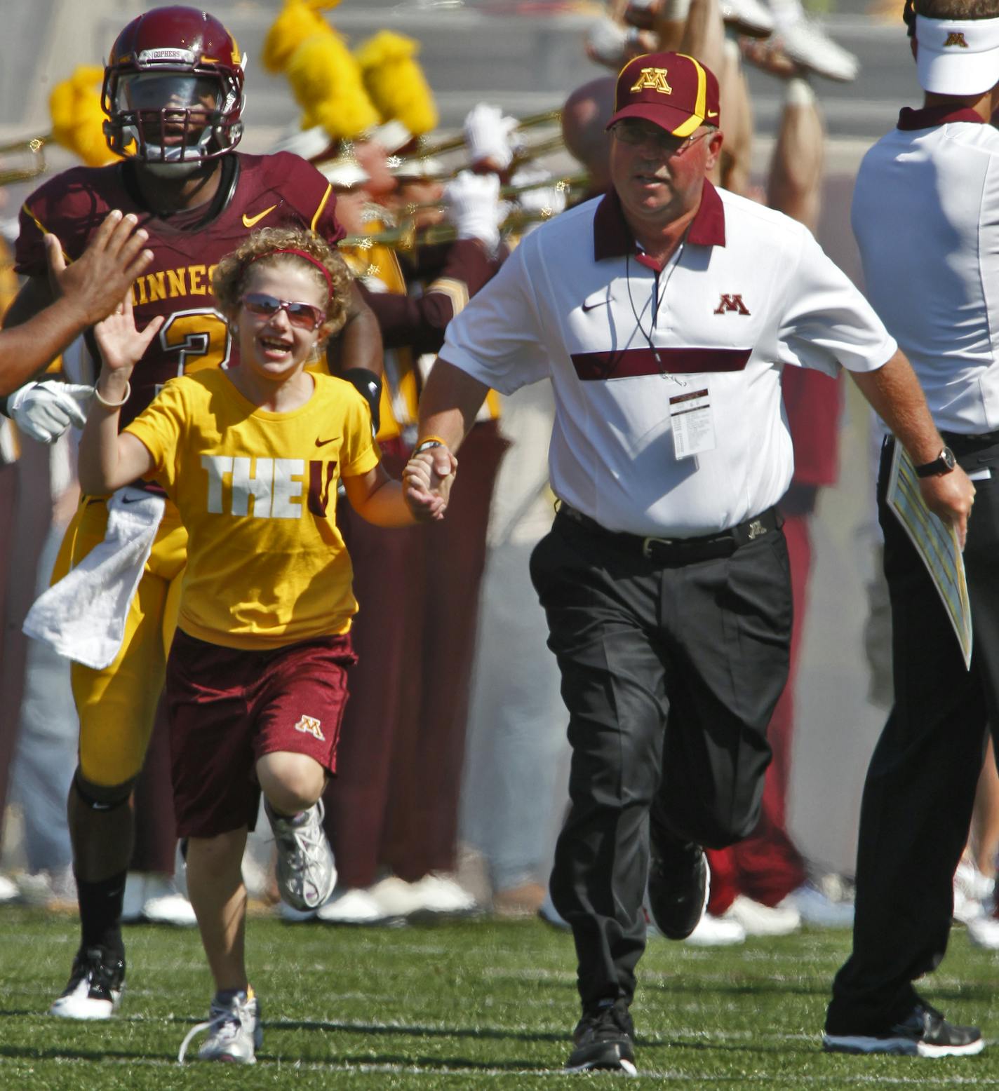 University of Minnesota vs. New Mexico State football. New Mexico State won 28-21. Head Minnesota football coach Jerry Kill, right led 10-year-old cancer patient Mia Gerold onto the field before the start of the game. ](MARLIN LEVISON/STARTRIBUNE(mlevison@startribune.com (cq )