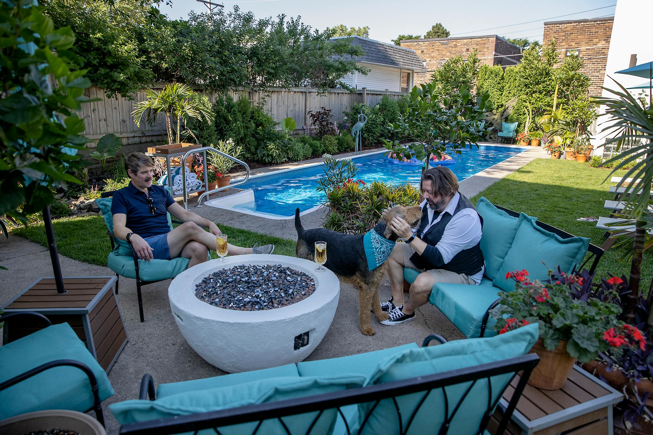 Sean Ryan, left, and Ed Piechowski, right, played with their dog "Buddy" at their home, Wednesday, June 30, 2021 in St. Paul, MN. They are part of a growing trend of pool owners who are using the Swimply app, called the Airbnb of pools, to rent out to people by the hour. ] ELIZABETH FLORES • liz.flores@startribune.com