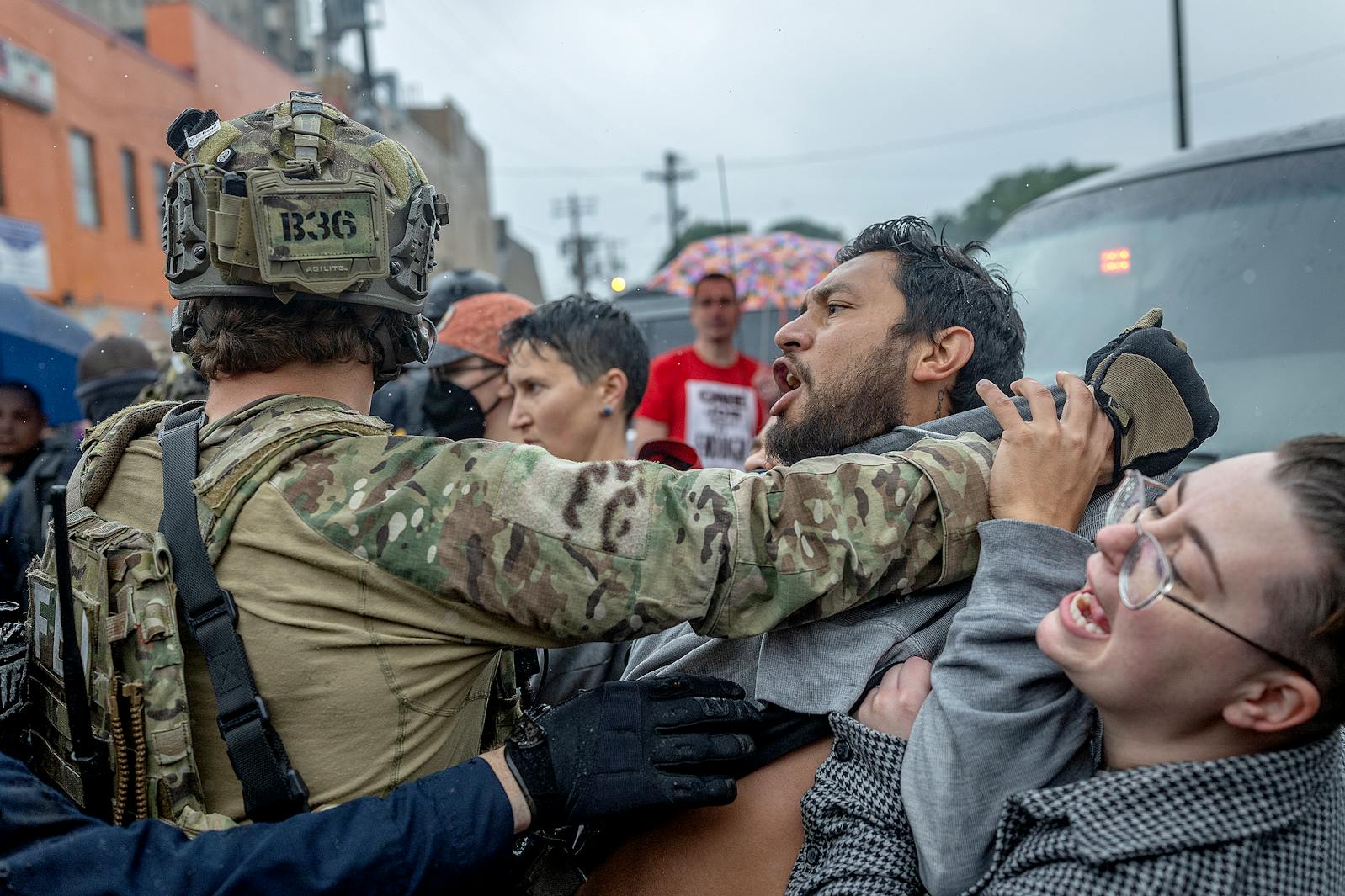 People confront law enforcement as they try to remove someone they detained outside Los Cuatro Milpas restaurant in Minneapolis on Tuesday. 