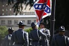 Members of the South Carolina State Police remove the Confederate battle flag from the grounds of the State House in Columbia, S.C., the morning of Ju