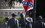 Members of the South Carolina State Police remove the Confederate battle flag from the grounds of the State House in Columbia, S.C., the morning of Ju
