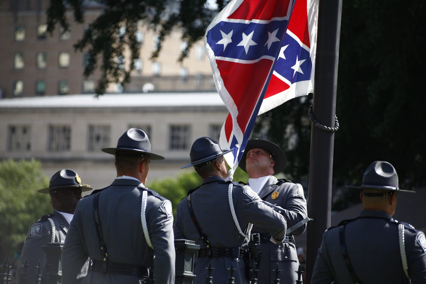 Members of the South Carolina State Police remove the Confederate battle flag from the grounds of the State House in Columbia, S.C., the morning of July 10, 2015. Closing a chapter on a symbol of the Deep South and its history of resistance and racial animus, the state on Friday lowered the flag from where it had flown for more than 50 years.