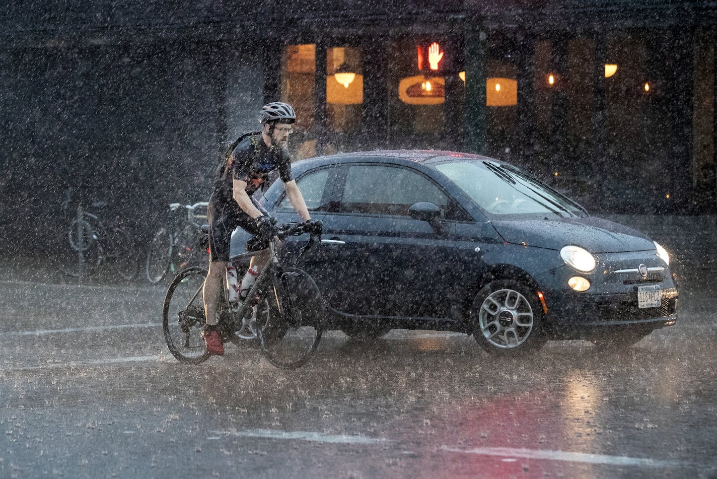 A cyclist crossed Lake Street in Minneapolis during a thunderstorm on Thursday.