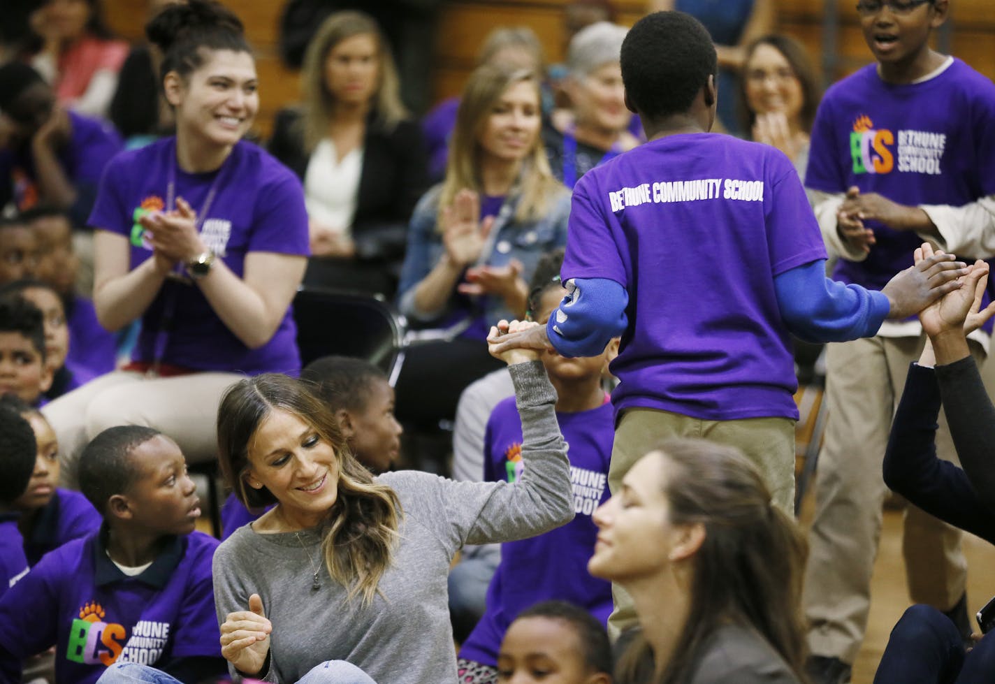 Actress Sarah Jessica Parker center a high fived a student after her performed during Bethune Elementary School talent assembly Monday May 18, 2015 in Minneapolis, MN. Sarah Jessica Parker attended an assembly at Bethune as part of the Turnaround Arts, a signature program of the President Committee on the Arts and the Humanities, run in Minnesota by the Perpich Center for Arts Education. ] Jerry Holt/ Jerry.Holt@Startribune.com