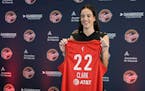 The Indiana Fever's Caitlin Clark holds her jersey after a news conference Wednesday in Indianapolis.