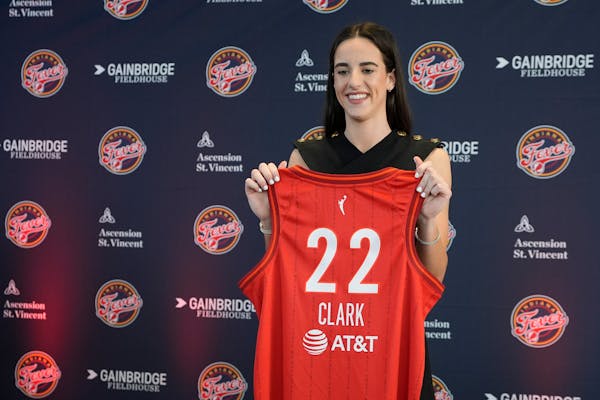 The Indiana Fever's Caitlin Clark holds her jersey after a news conference Wednesday in Indianapolis.