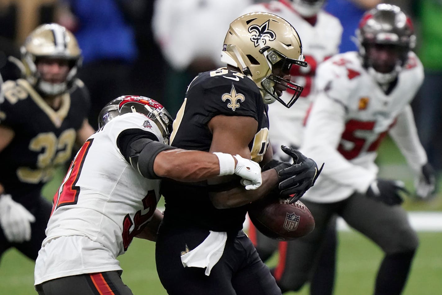 New Orleans Saints tight end Jared Cook, center, fumbles the ball as he is hit by Tampa Bay Buccaneers strong safety Antoine Winfield Jr. during the second half of an NFL divisional round playoff football game, Sunday, Jan. 17, 2021, in New Orleans. The Buccaneers' Devin White recovered the ball. (AP Photo/Brynn Anderson)