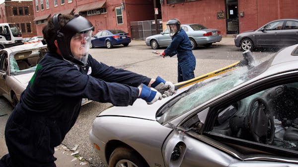 Matt Cummings and Emily Dusold of Anchor Paper in St. Paul smashed a car as part of Give to the Max Day. ] GLEN STUBBE * gstubbe@startribune.com Thurs