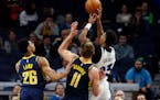 The Timberwolves' Jarrett Culver shoots as the Pacers' Jeremy Lamb, left, and Domantas Sabonis defend.