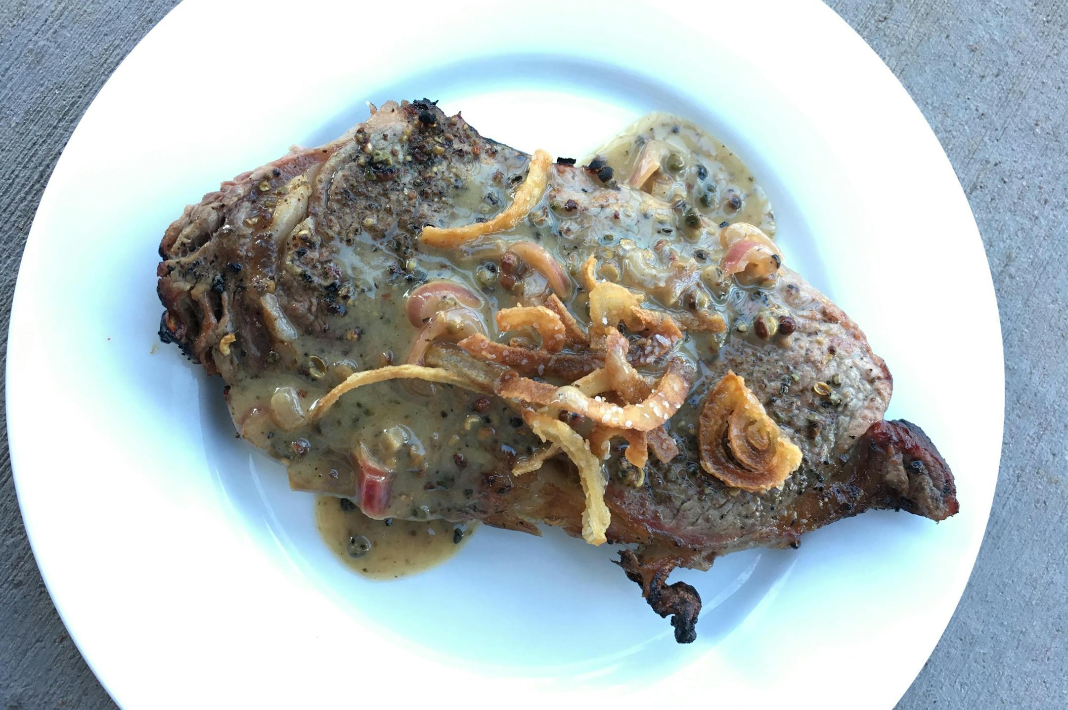 Grilled Rib-Eye Steak Au Poivre With Onion Straws.