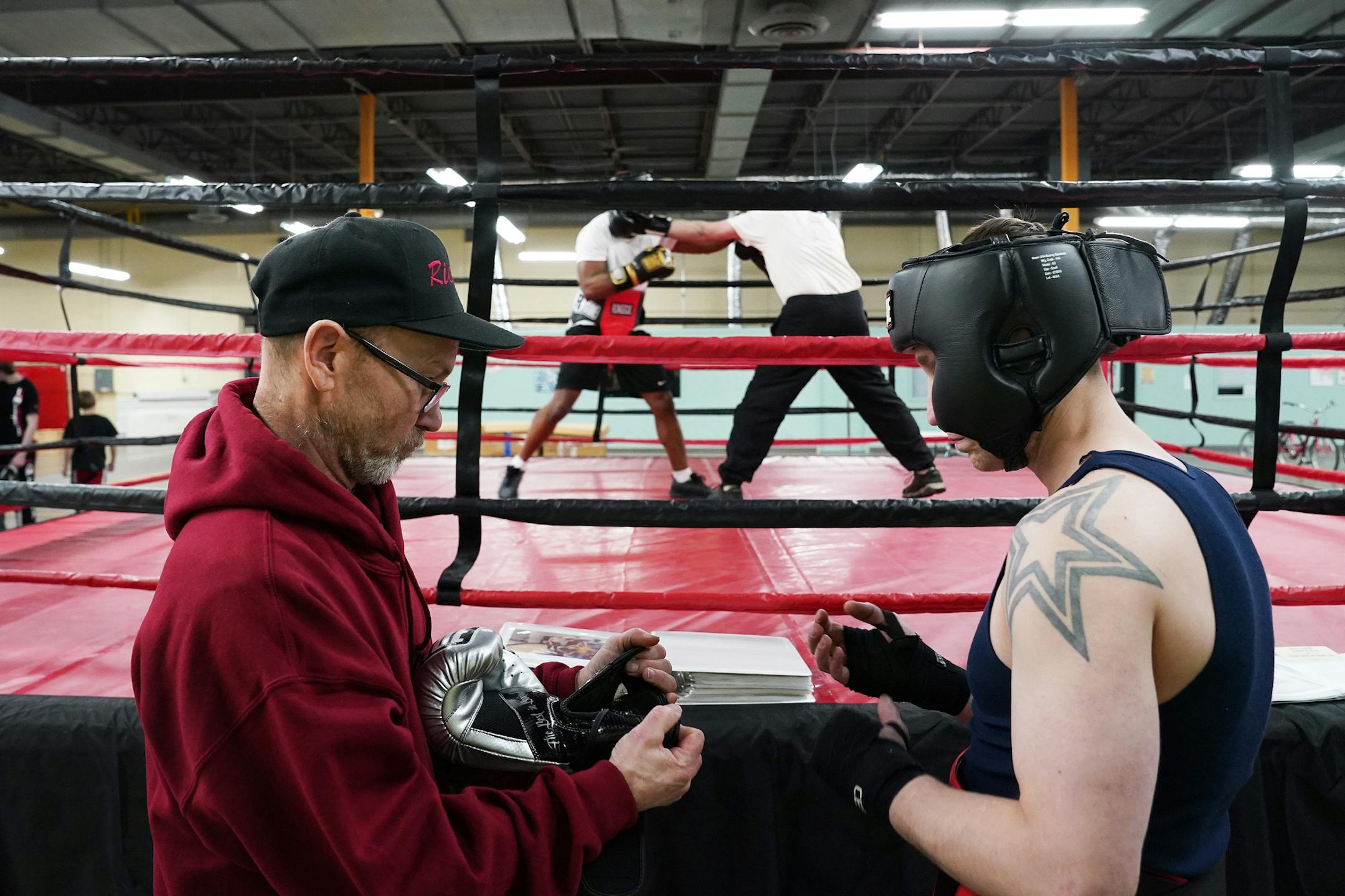 Mike Evgen helped Josh Denn with his gloves. ] ANTHONY SOUFFLE • anthony.souffle@startribune.com Mike Evgen, the former Rice Street Rocker of area pro boxing fame, worked out with some of his fighters at his new boxing gym the Rice Street Old School Boxing Gym (though it's not on Rice Street) Thursday, Jan. 23, 2020 in St. Paul, Minn.