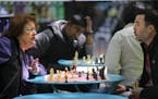 Chess lover Karen Schmidt, left, plays a lunchtime game of chess with Tyson Supasatit at Westlake Park in downtown Seattle. Supasatit works nearby at 