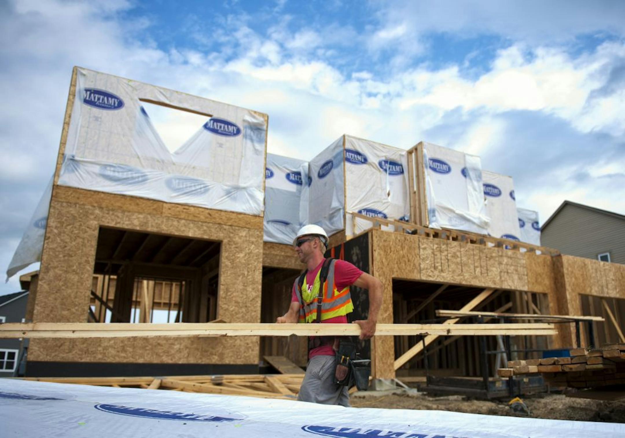 A crew from Carpentry Contractors puts house wrap on roof trusses on a Mattamy Corp home in the Chevalle Developmentin Chaska. Wednesday, June 20, 2012