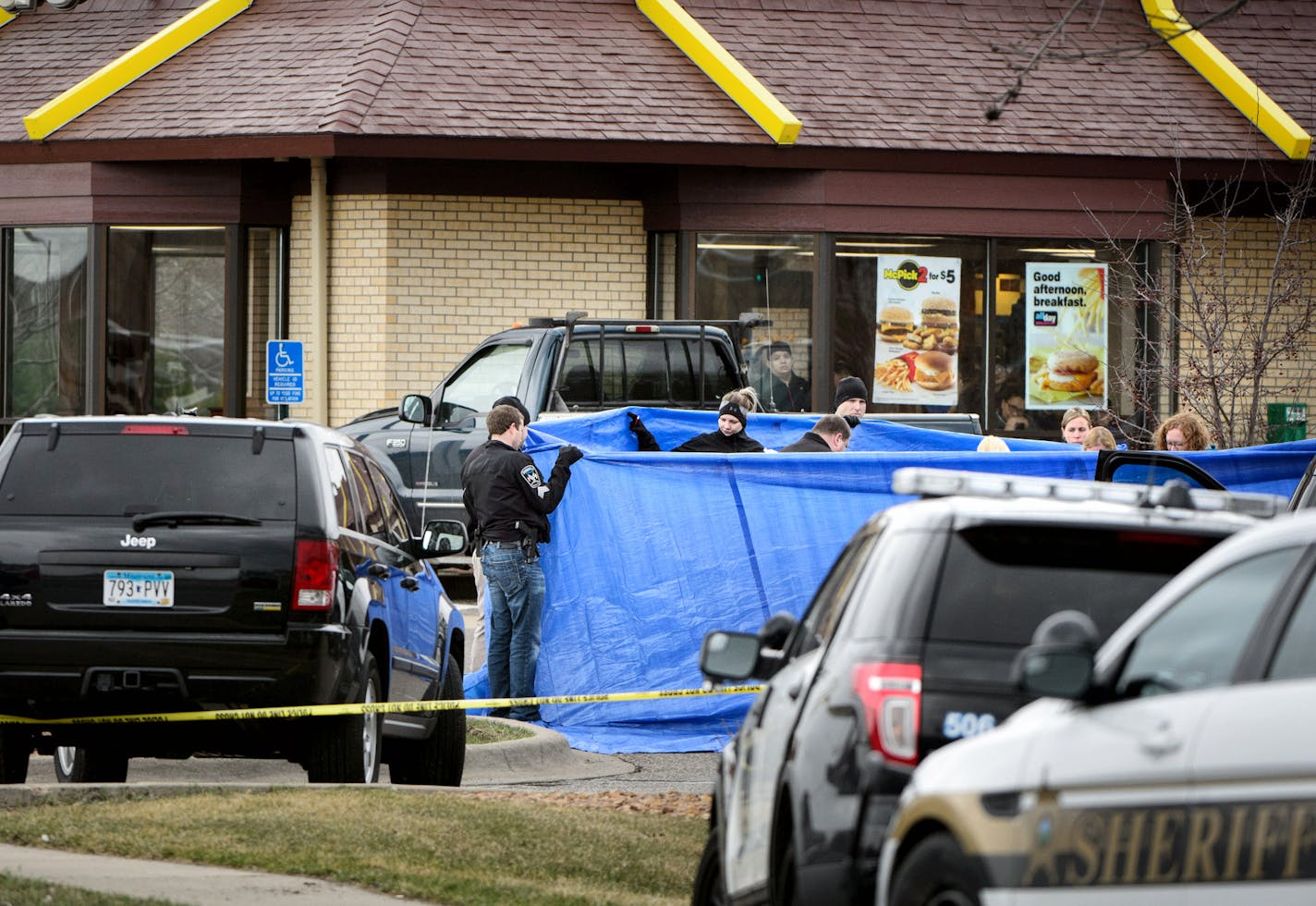 Burnsville Police held a tarp around the body as BCA investigators and Medical Examiners investigated a shooting that occured in a McDonald's parking lot Thursday morning involving a Burnsville police officer. ] GLEN STUBBE * gstubbe@startribune.com Thursday March 17, 2016 EDS, graphic content, covered body of victim in parking lot