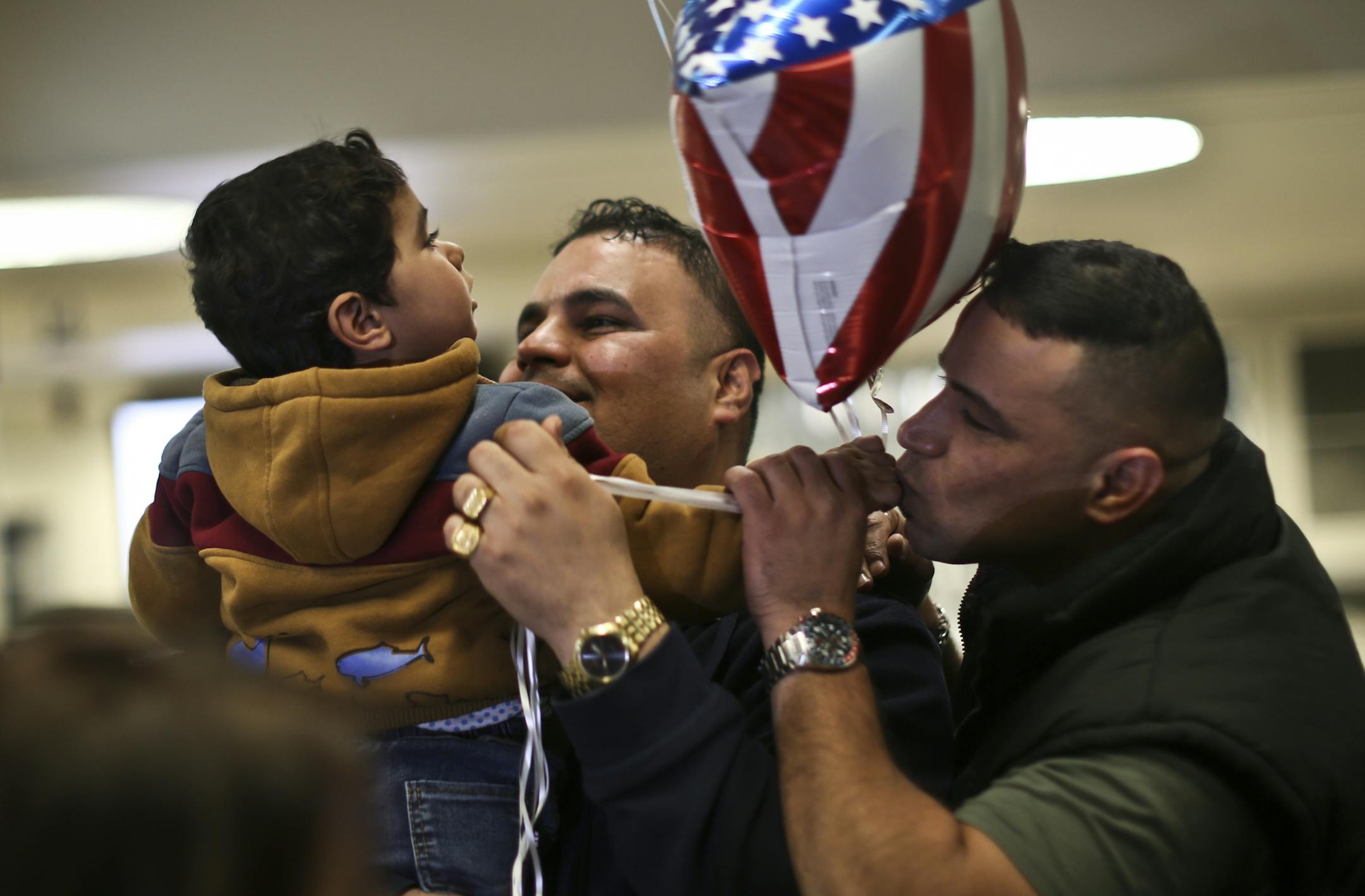 Iraqi refugee Mishaal Alkadi was reunited with the two-year-old son, Amer, at the Minneapolis/St. Paul International airport on Wednesday, April 24, 2013. His wife and the boy's mother was killed by terrorists as she and the boy waited to leave and rejoin Alkadi in the US. ] (RENEE JONES SCHNEIDER * reneejones@startribune.com) at right is an uncle whose name I do not have but ML will.