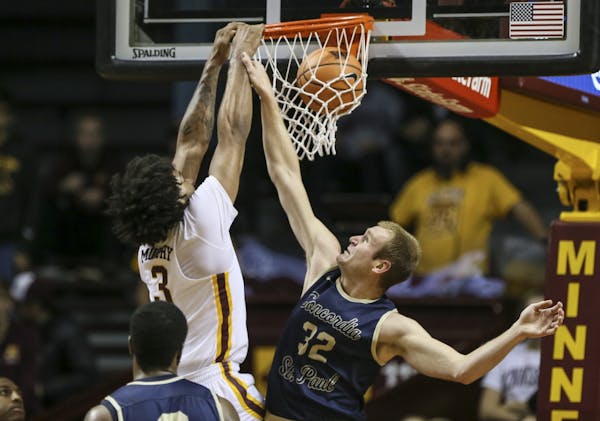 Minnesota's Jordan Murphy (3) dunked the ball during the first half as Concordia's Max Keefe (32) tried to stop him.