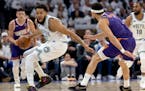 Karl-Anthony Towns of the Wolves is defended by Devin Booker of the Suns on Tuesday night at Target Center.