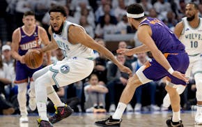 Karl-Anthony Towns of the Wolves is defended by Phoenix guard Devin Booker on Tuesday night at Target Center.