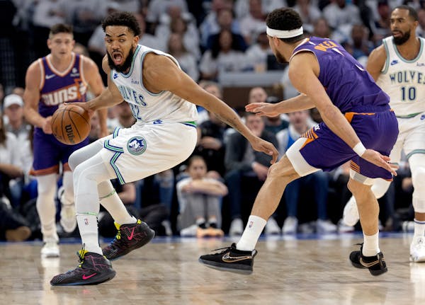 Karl-Anthony Towns of the Wolves is defended by Phoenix guard Devin Booker on Tuesday night at Target Center.