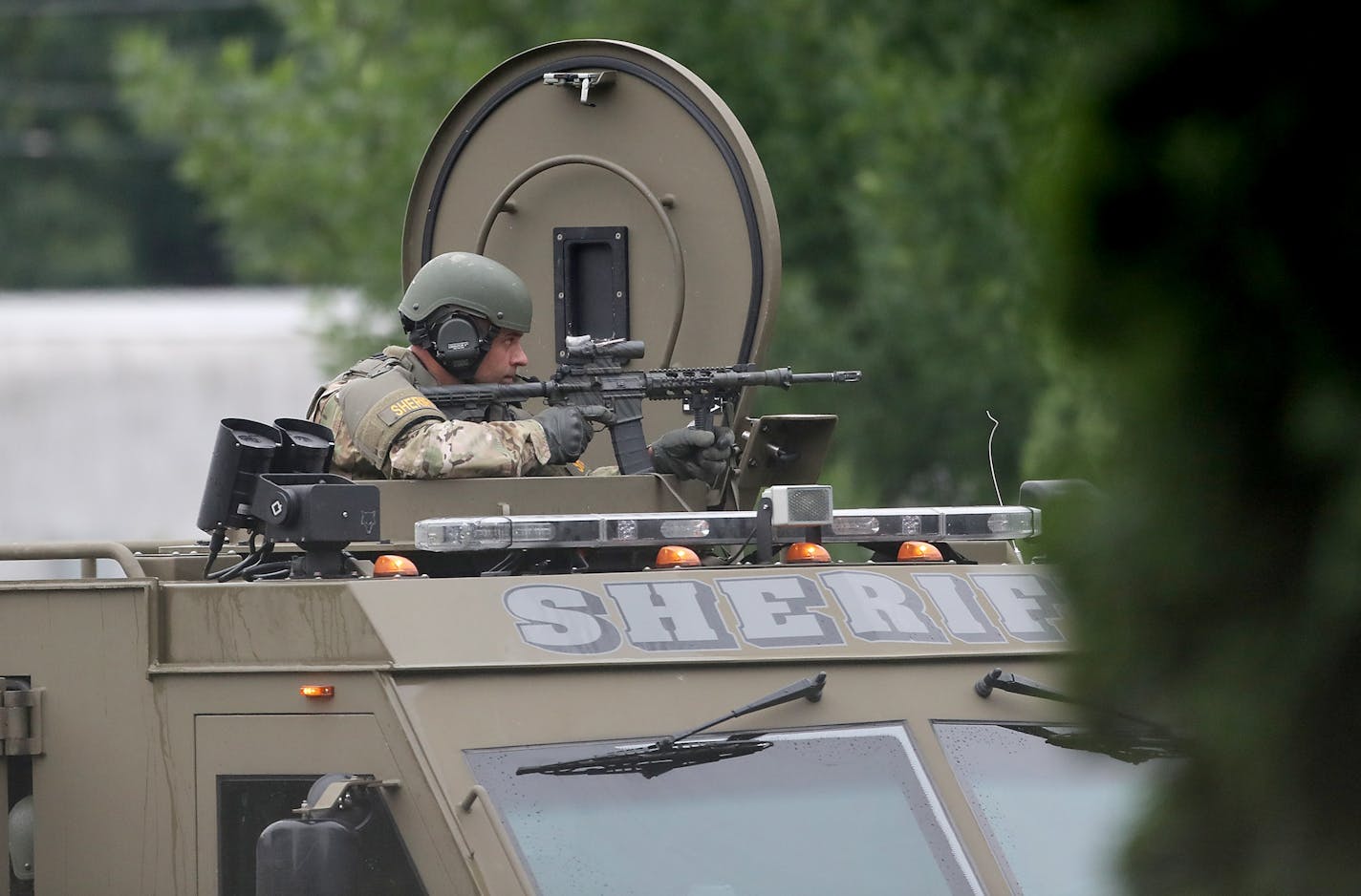 A sheriff's department SWAT member keeps an eye toward a New Hope apartment where a man was barricaded inside Tuesday. The man was later captured by police.