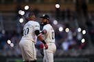 Minnesota Twins first baseman Carlos Santana (30) and out fielder Manuel Margot (13) joke with each other before the start of the 8th inning against t