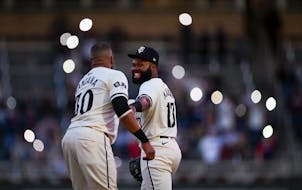 Minnesota Twins first baseman Carlos Santana (30) and out fielder Manuel Margot (13) joke with each other before the start of the 8th inning against t