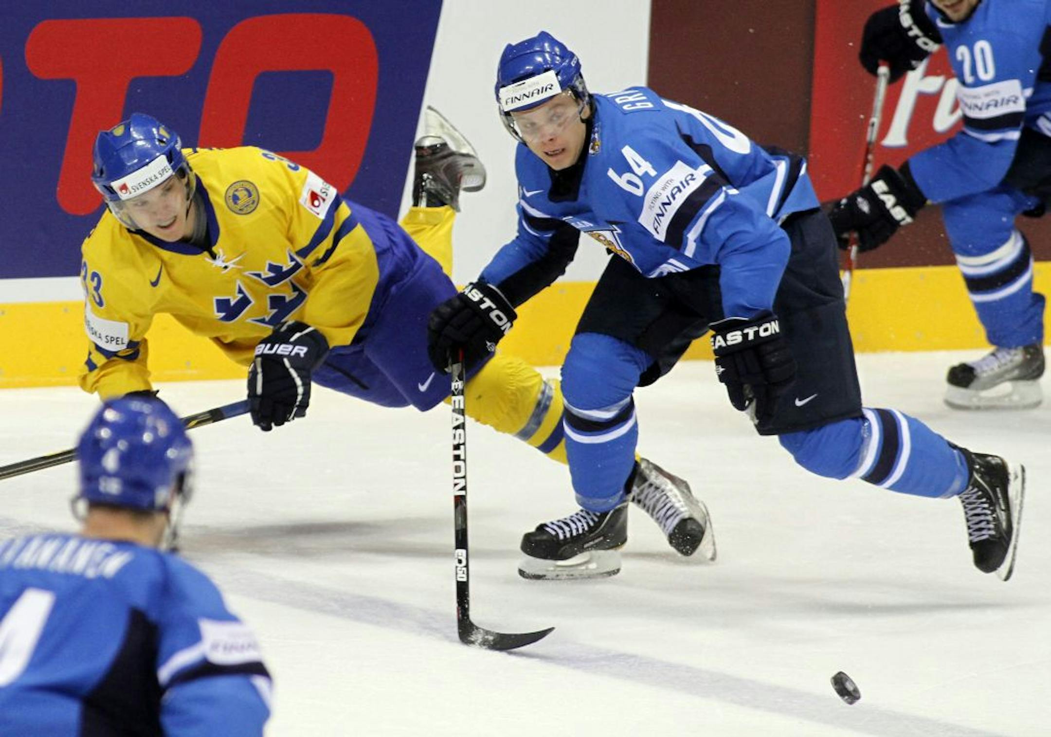 Sweden's Jakob Silfverberg, left, challenges for the puck with Finland's Mikael Granlund.