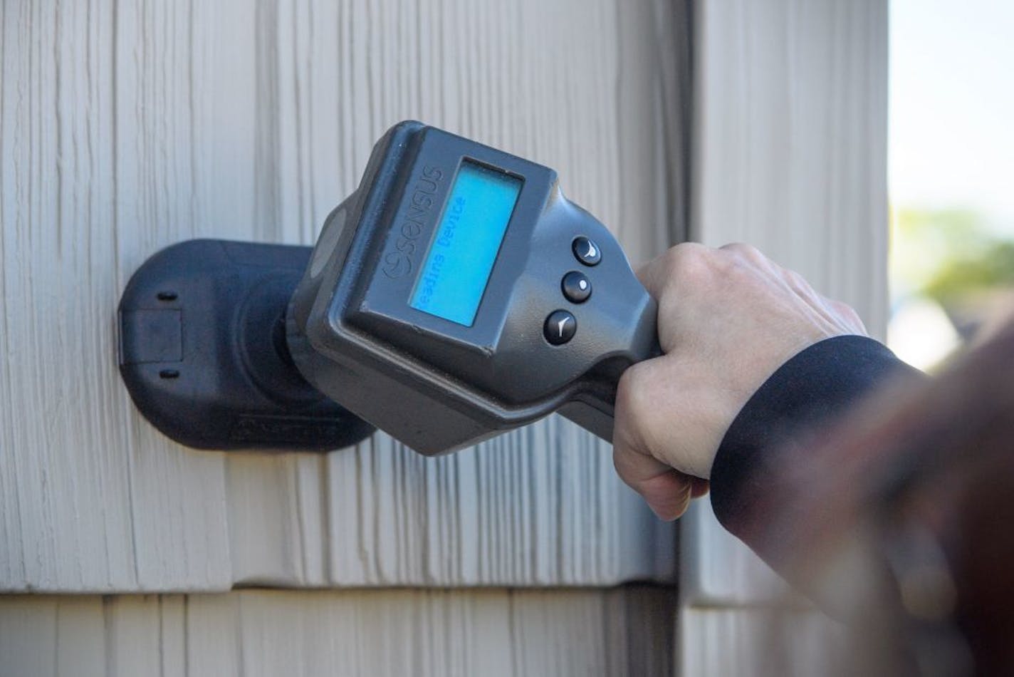 Jenny Rhoades, a public works meter reader for Bloomington walked briskly from house to house in a new Bloomington neighborhood capturing water readings from a sensor on the side of each house.