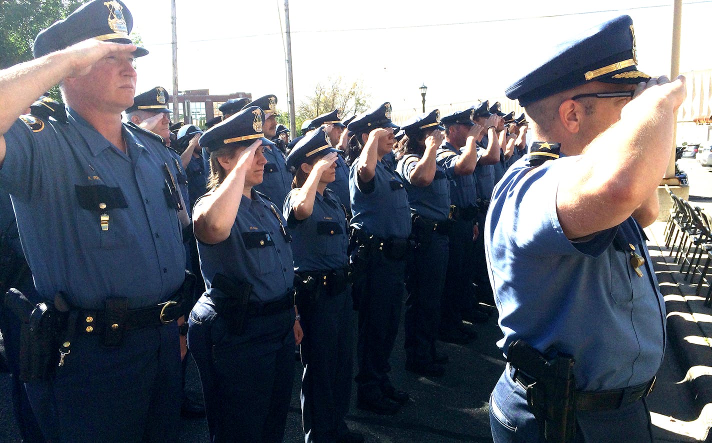 St. Paul police officers salute as a flag is raised in honor of Officers Ron Ryan Jr. and Tim Jones at a brief ceremony at police headquarters.