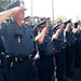 St. Paul police officers salute as a flag is raised in honor of Officers Ron Ryan Jr. and Tim Jones at a brief ceremony at police headquarters.