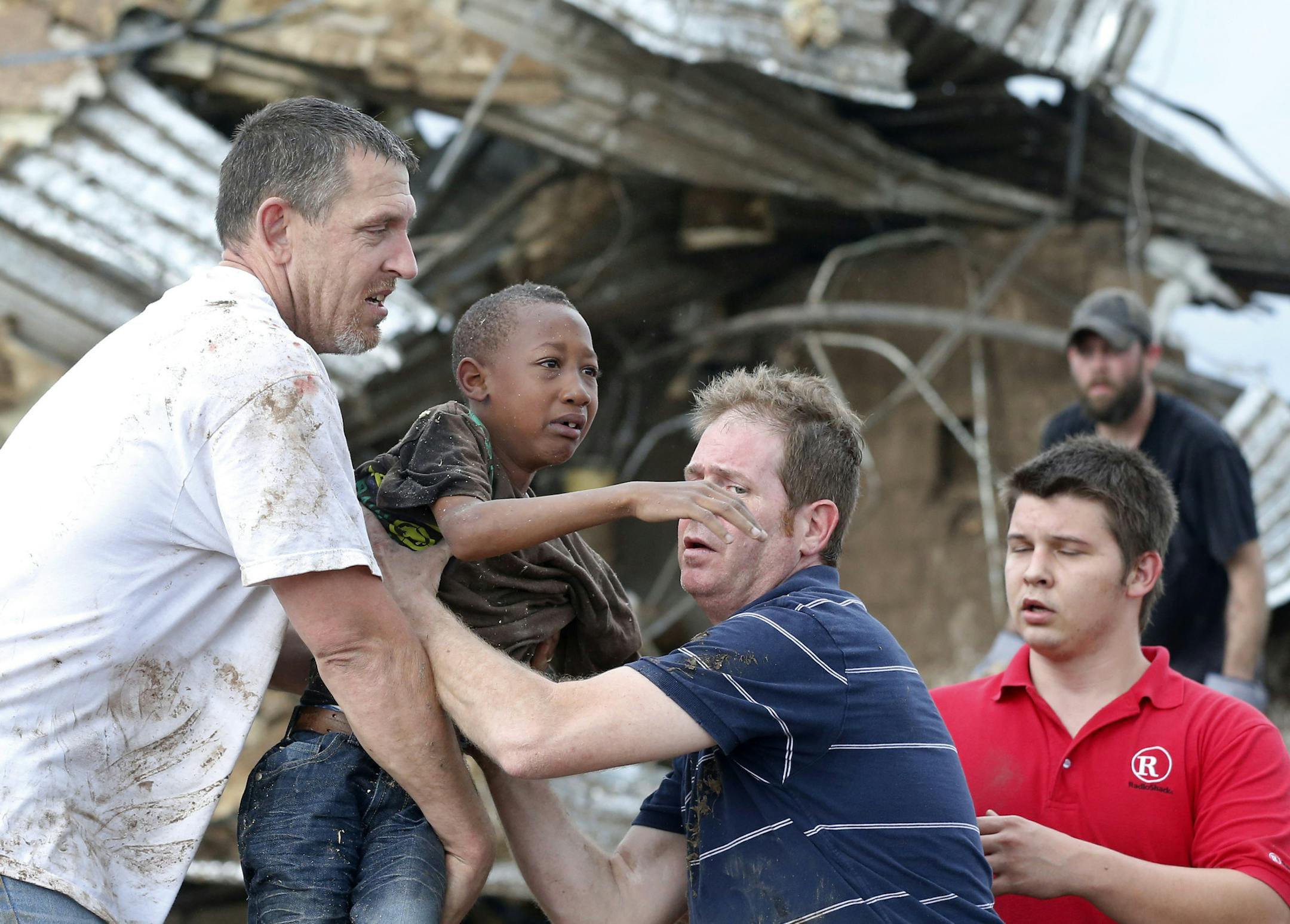 May 20, 2013: Cameron Richardson, center, is carried out of the rubble of Plaza Towers Elementary school in Moore, Okla.