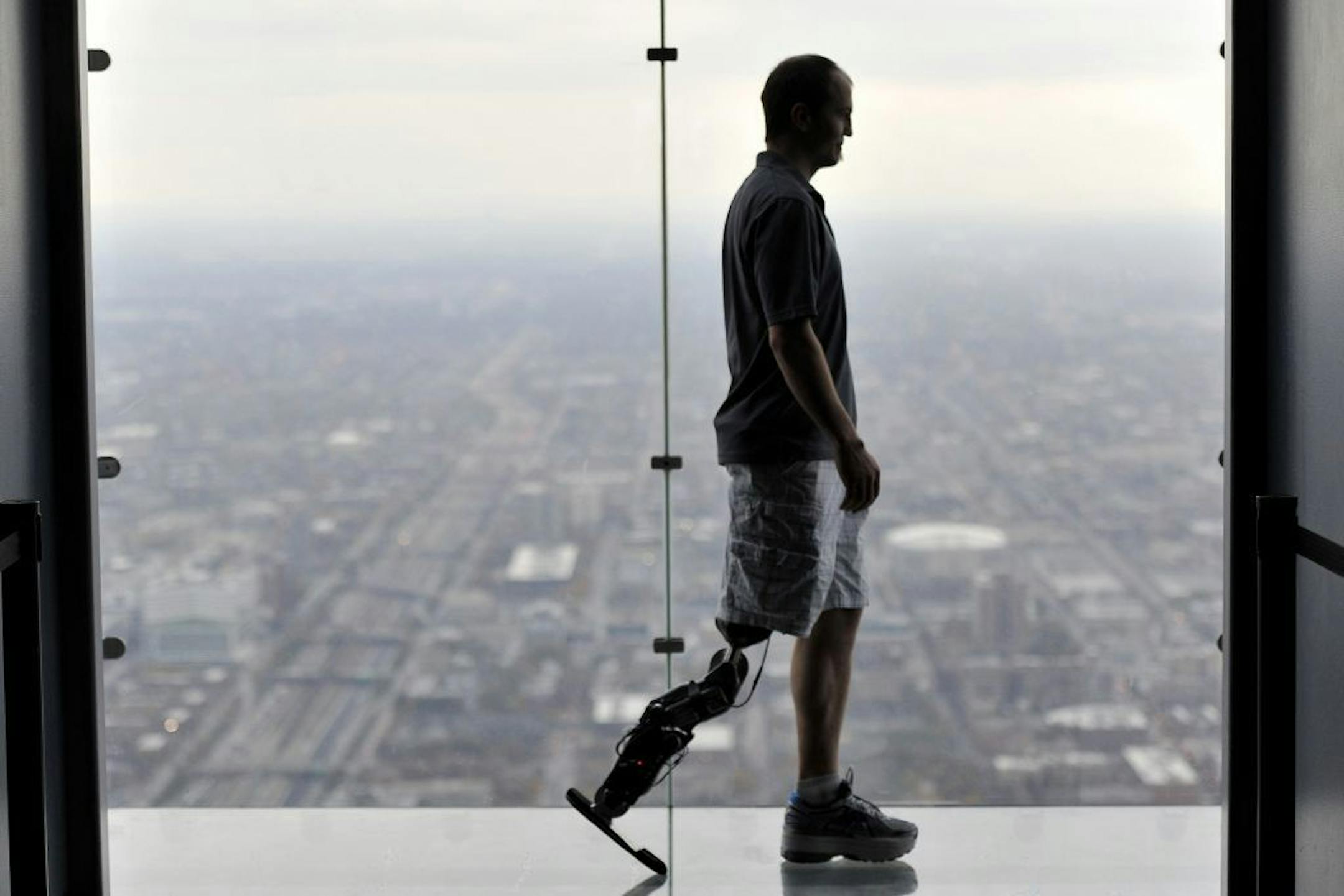 In this Oct. 25, 2012 photo, Zac Vawter, fitted with an experimental "bionic" leg, is silhouetted on the Ledge at the Willis Tower in Chicago. Vawter is training for the world's tallest stair-climbing event where he'll attempt to climb 103 flights to the top of theWillis Tower using the new prosthesis.