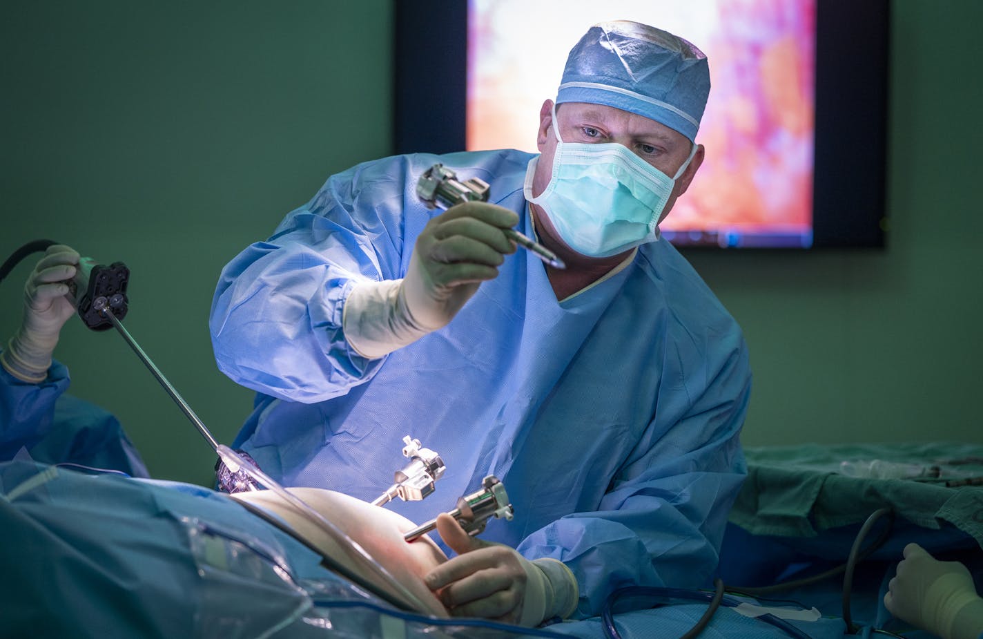 Dr. Jared Slater prepared a patient for robotic gall bladder surgery at RC Hospital and Clinics in Olivia, Minn. The hospital gambled that investing in the robotic surgery tool and expanded obstetrics care would lure patients back. So far, the investment seems to be paying off.