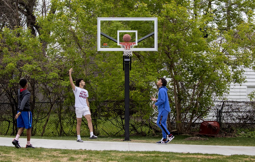 C.J. Brown, middle, and Davon Townley, right, hung out at the home of Datrell McCrimmon in north Minneapolis. Driveway backboards have become precious commodities.