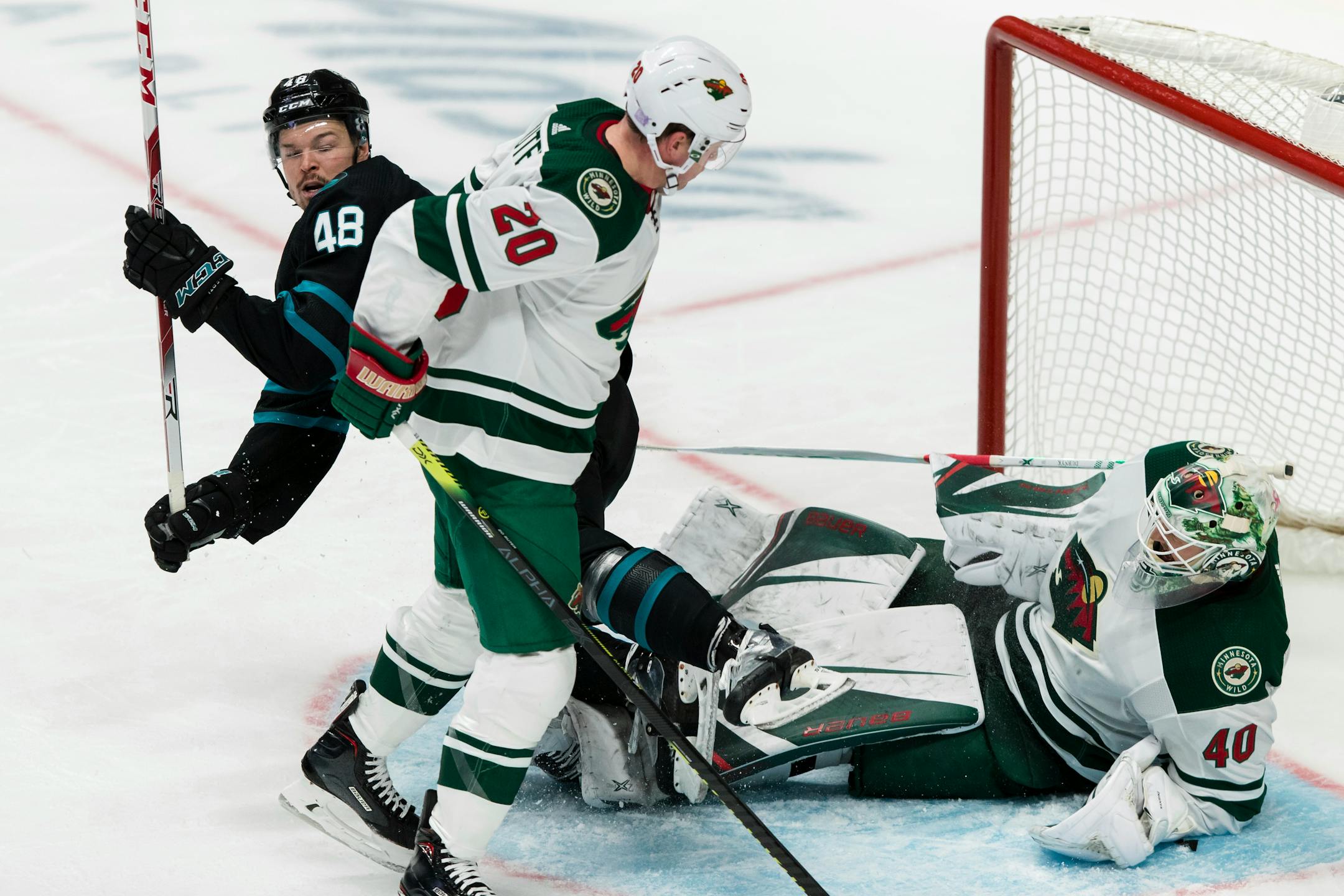 Minnesota Wild goaltender Devan Dubnyk (40) smothers the puck as Ryan Suter (20) and San Jose Sharks' Tomas Hertl (48) collide during the third period of an NHL hockey game, Thursday, Nov. 7, 2019, in San Jose, Calif. The Sharks won 6-5. (AP Photo/John Hefti)