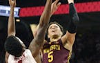 Minnesota guard Amir Coffey, right, tries to drive past Arkansas defender Daryl Macon, left, in the second half of an NCAA college basketball game Sat