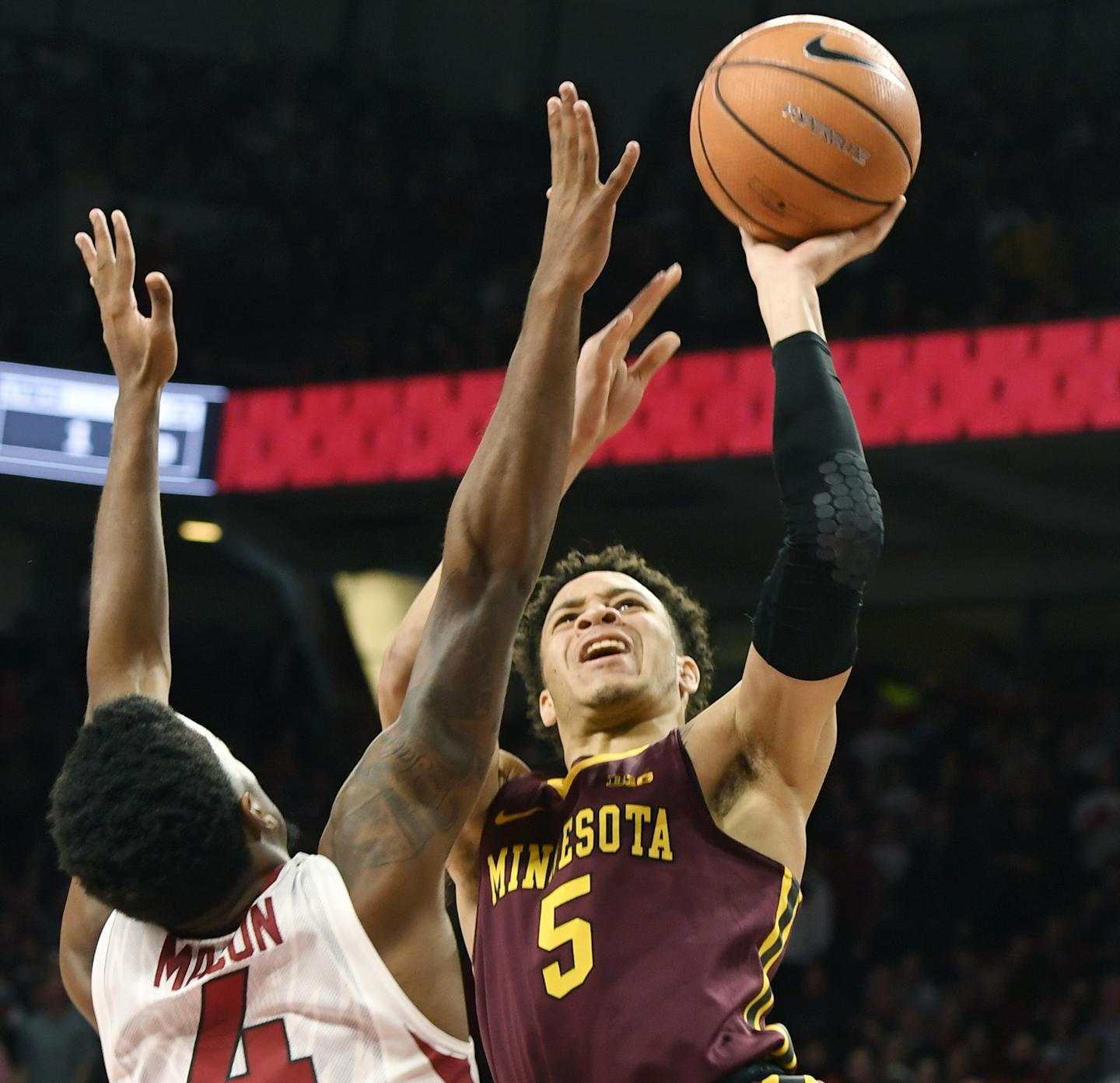 Minnesota guard Amir Coffey, right, tries to drive past Arkansas defender Daryl Macon, left, in the second half of an NCAA college basketball game Saturday, Dec. 9, 2017 in Fayetteville, Ark. (AP Photo/Michael Woods)