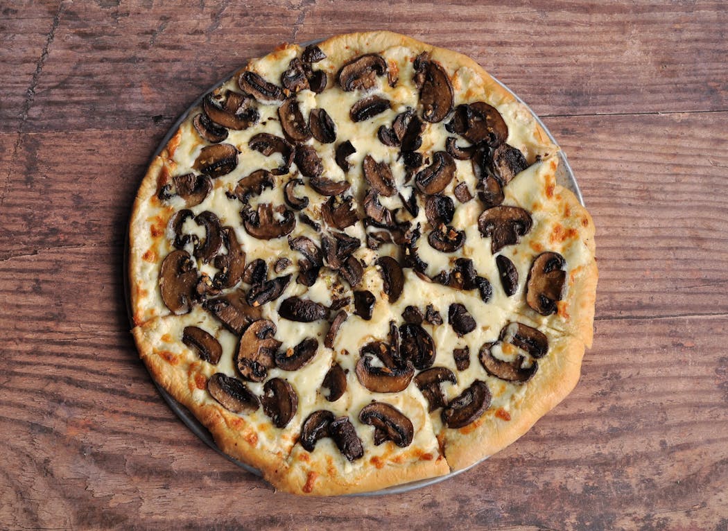 The crisp Roasted Mushroom Pizza is topped with mascarpone cheese. 