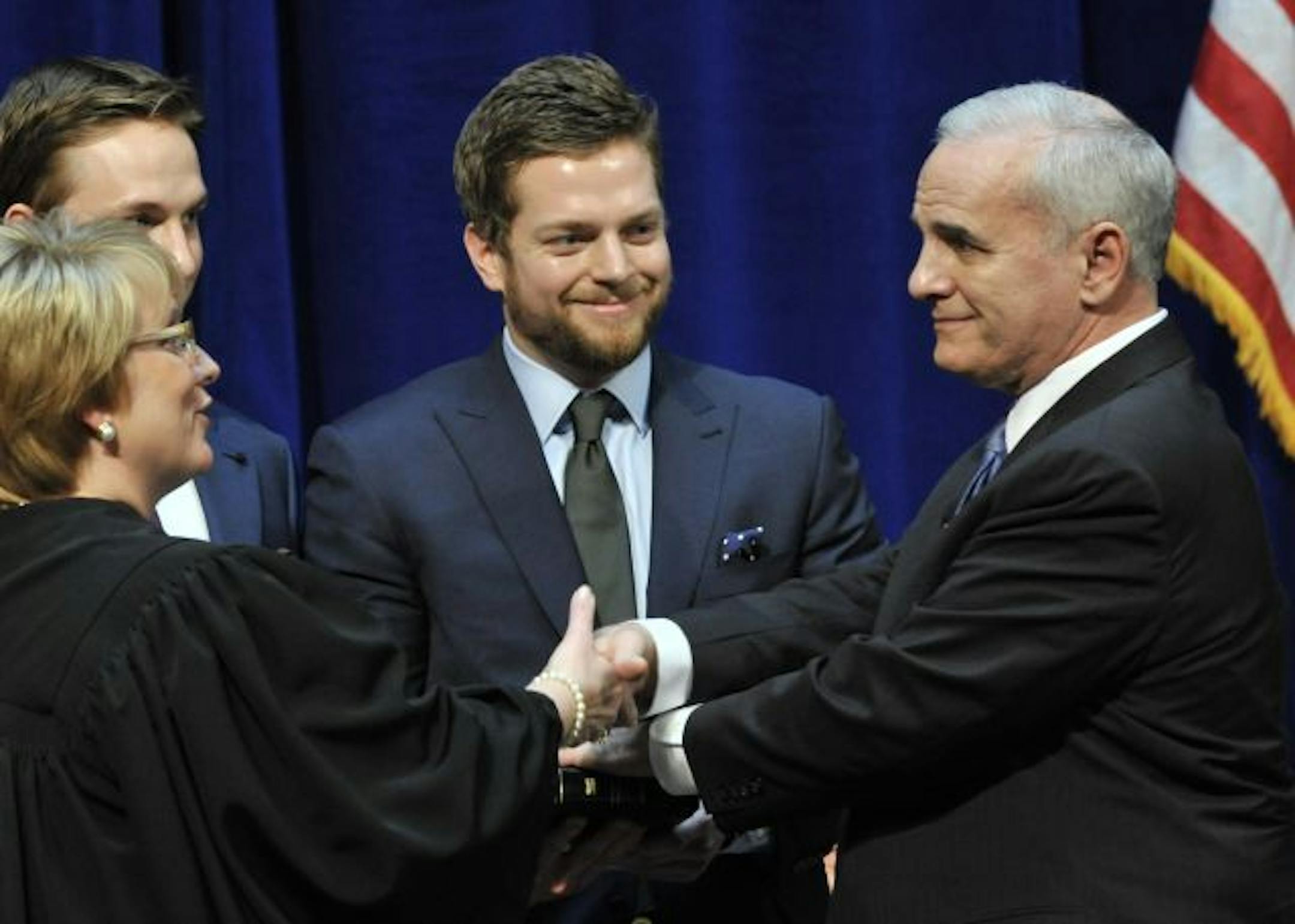 Former U.S. Sen. Mark Dayton, right, shakes hands with Supreme Court Chief Justice Lorie Skjerven Gildea as sons Andrew, left, and Eric look on Monday, Jan. 3, 2011 in St. Paul, Minn., after he took the oath of office for Minnesota governor.