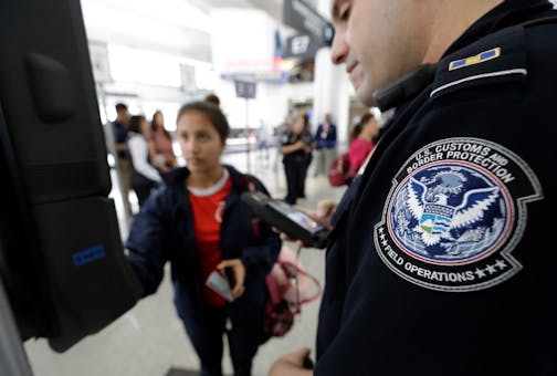 U.S. Customs and Border Protection officer Julio Corro, right, helps a passenger navigate one of the new facial recognition kiosks at a United Airlines gate before boarding a flight to Tokyo, Wednesday, July 12, 2017, at George Bush Intercontinental Airport, in Houston. The Trump administration intends to require that American citizens boarding international flights submit to face scans, something Congress has not explicitly approved and privacy advocates consider an ill-advised step toward a su