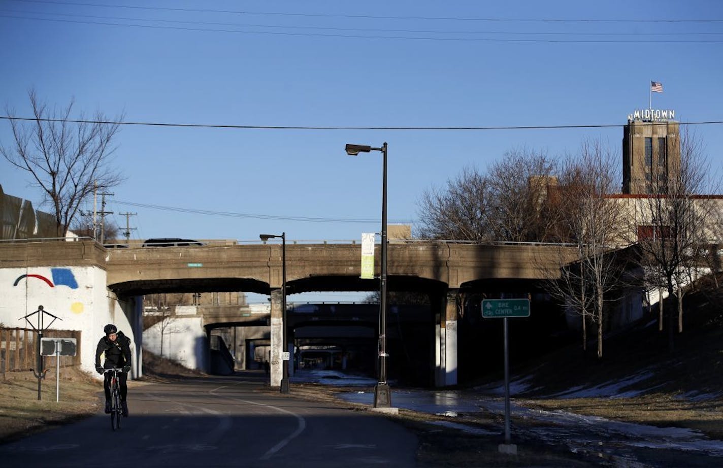 A cyclist riding on the Midtown Greenway passed near the Portland Avenue Bridge in Minneapolis.