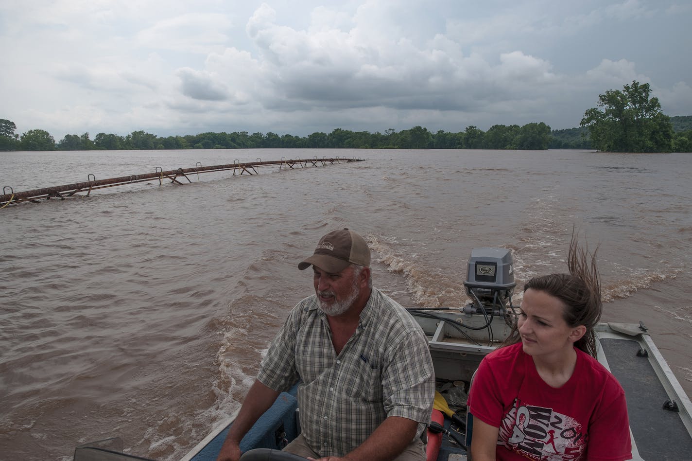 Chris Schaefers, left, and his neighbor and fellow farmer, Jill Edwards, pass an irrigation system nearly covered by floodwaters in swamped crop fields in Faulkner County, Ark., June 5, 2019. Fast currents and swollen channels have rendered many rivers unsafe for commercial traffic, spreading economic pain from a spring of severe floods.