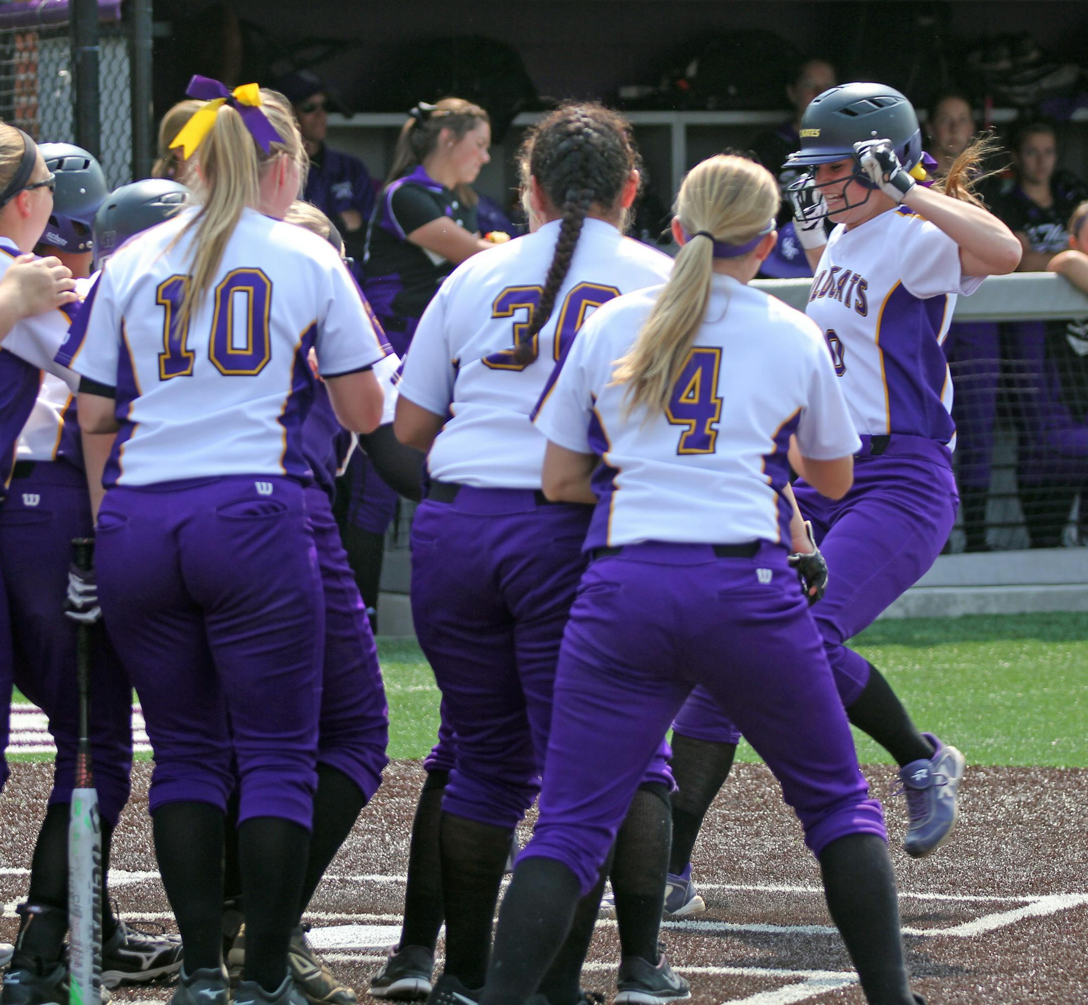 Megan Lindenfelser of St. Catherine University reaches home plate with her teammates waiting to celebrate after hitting a home run against St. Thomas in the MIAC tournament. PHOTO COURTESY OF ST. CATHERINE UNIVERSITY