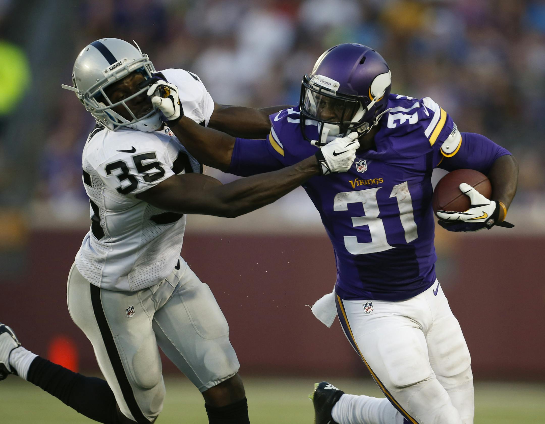 Minnesota Vikings running back Jerick McKinnon (31) stiff armed Oakland Raiders defensive back Chimdi Chekwa (35) as he made a two yard gain in the second quarter.